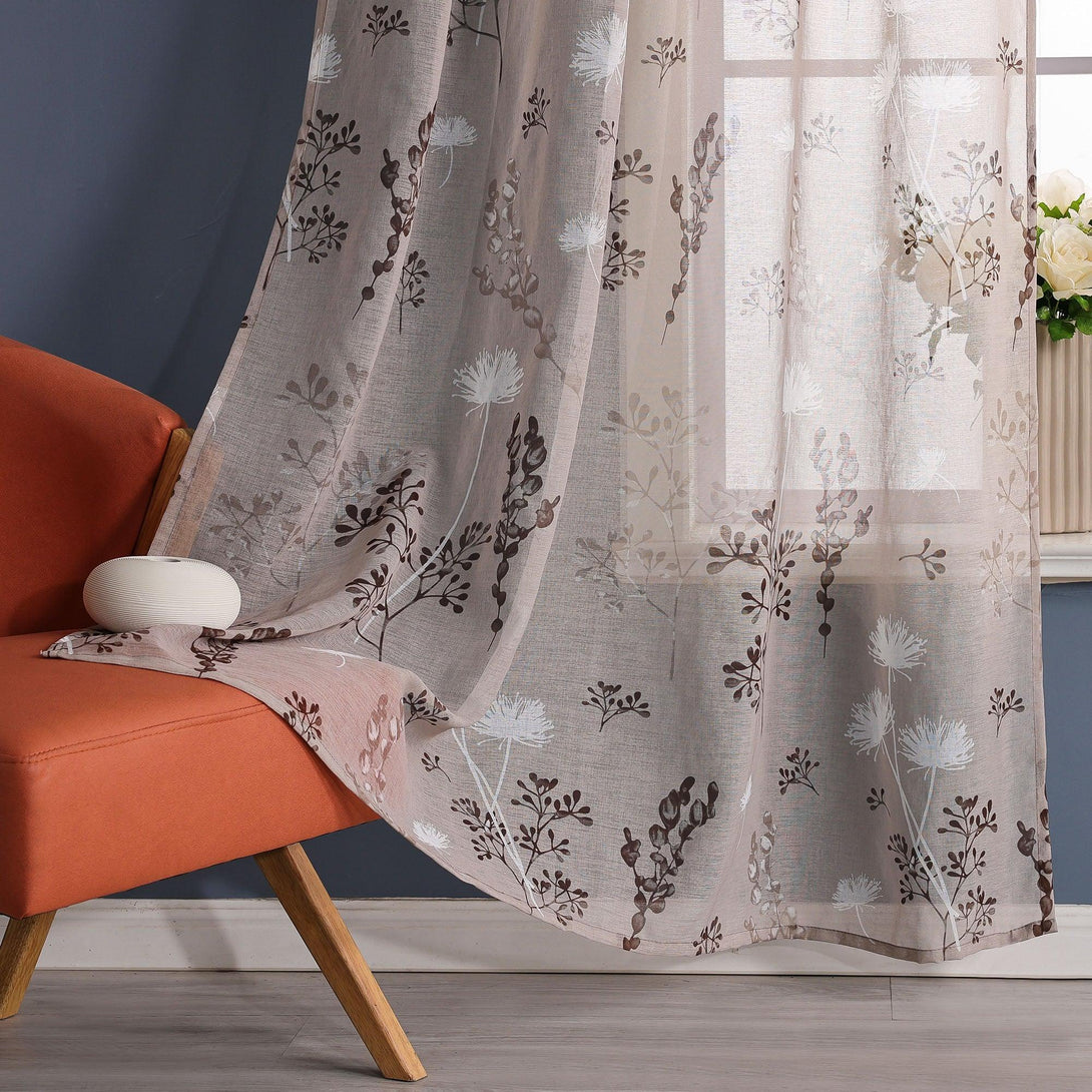 Die Szene zeigt eine Ecke eines Raumes mit einer blauen Wand, an der ein transparenter Vorhang mit einem Blumenmuster aus weißen Löwenzahnblumen und tiefbraunen Zweigen und Blättern hängt. Daneben steht ein hellgrünes Sofa mit Holzbeinen.