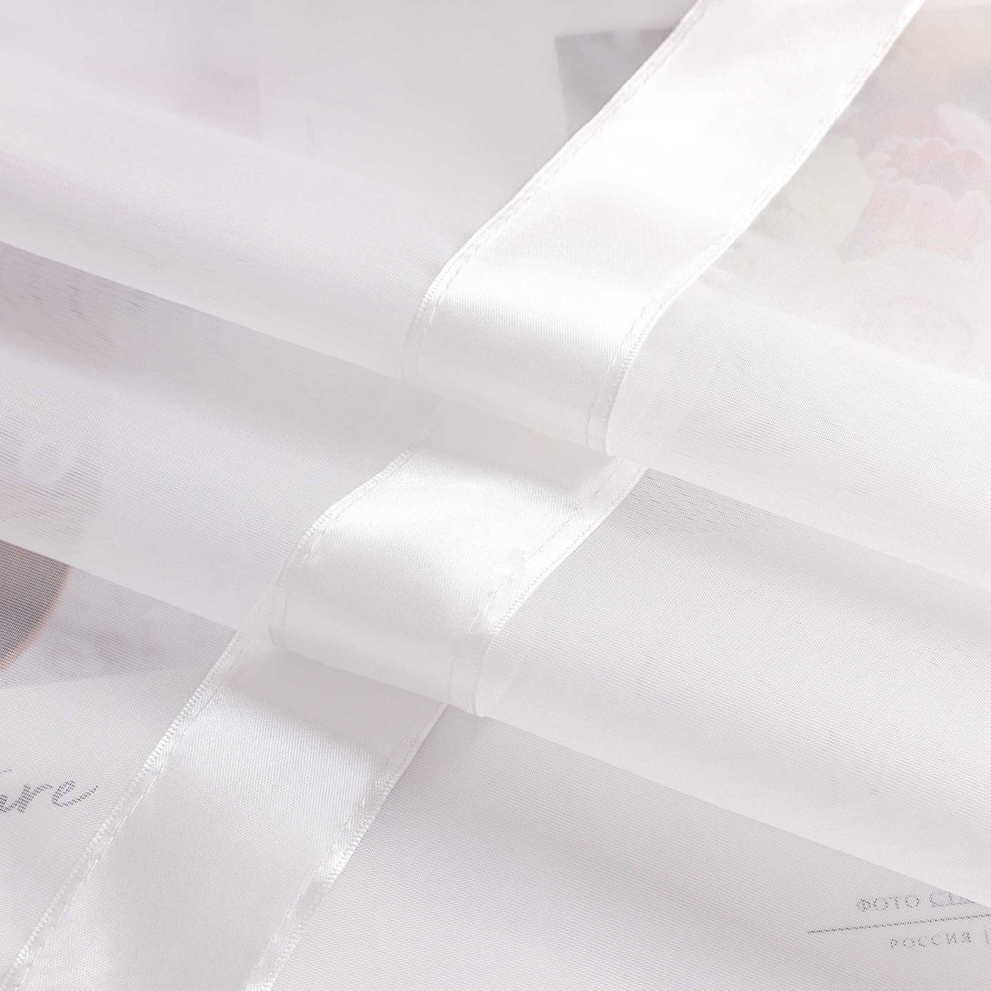 Das Bild zeigt weissen Voile-Stoff mit mehreren aufgenaehten weissen Satinbaendern. Die Satinbaender setzen sich vom transparenten Material ab und verleihen dem Vorhang eine feine, strukturierte Optik.