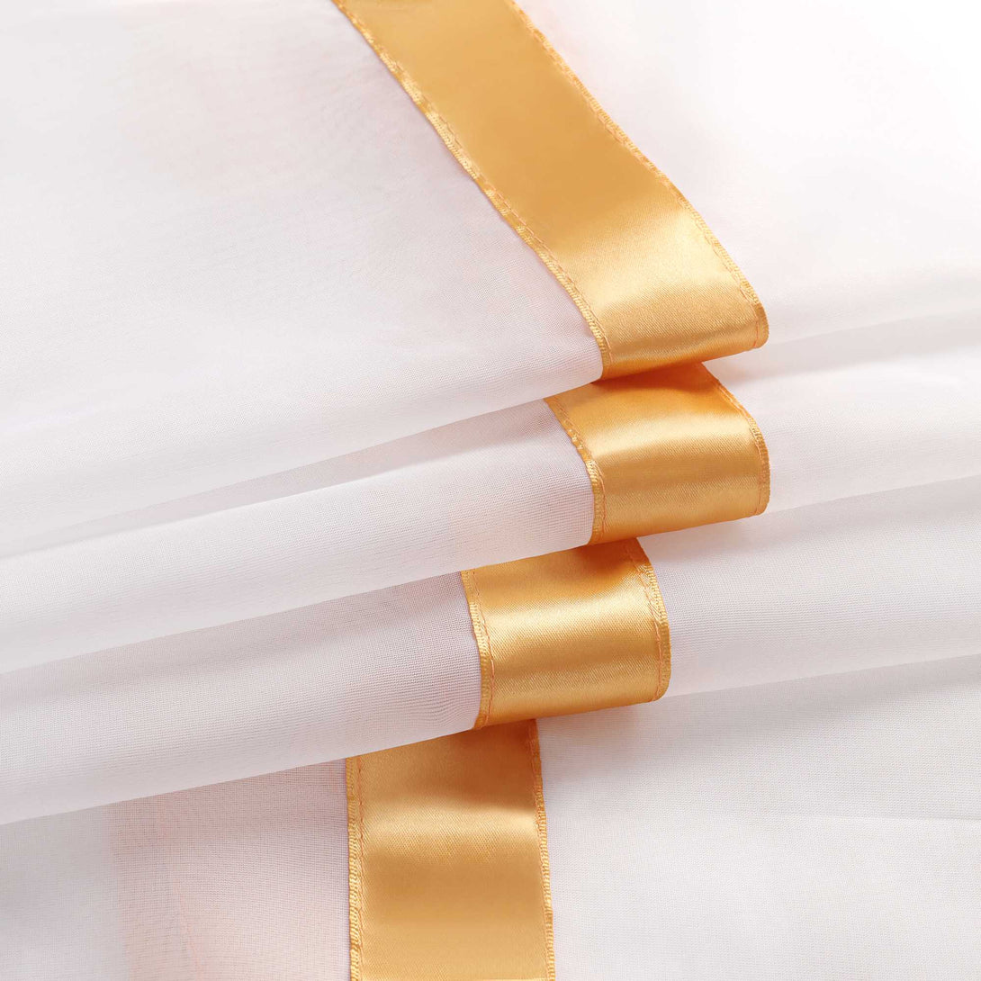 Das Bild zeigt einen weissen Voile-Stoff mit mehreren aufgenaehten orangefarbenen Satinbaendern. Die Baender setzen sich vom transparenten Stoff ab und verleihen dem Vorhang eine feine, strukturierte Optik.