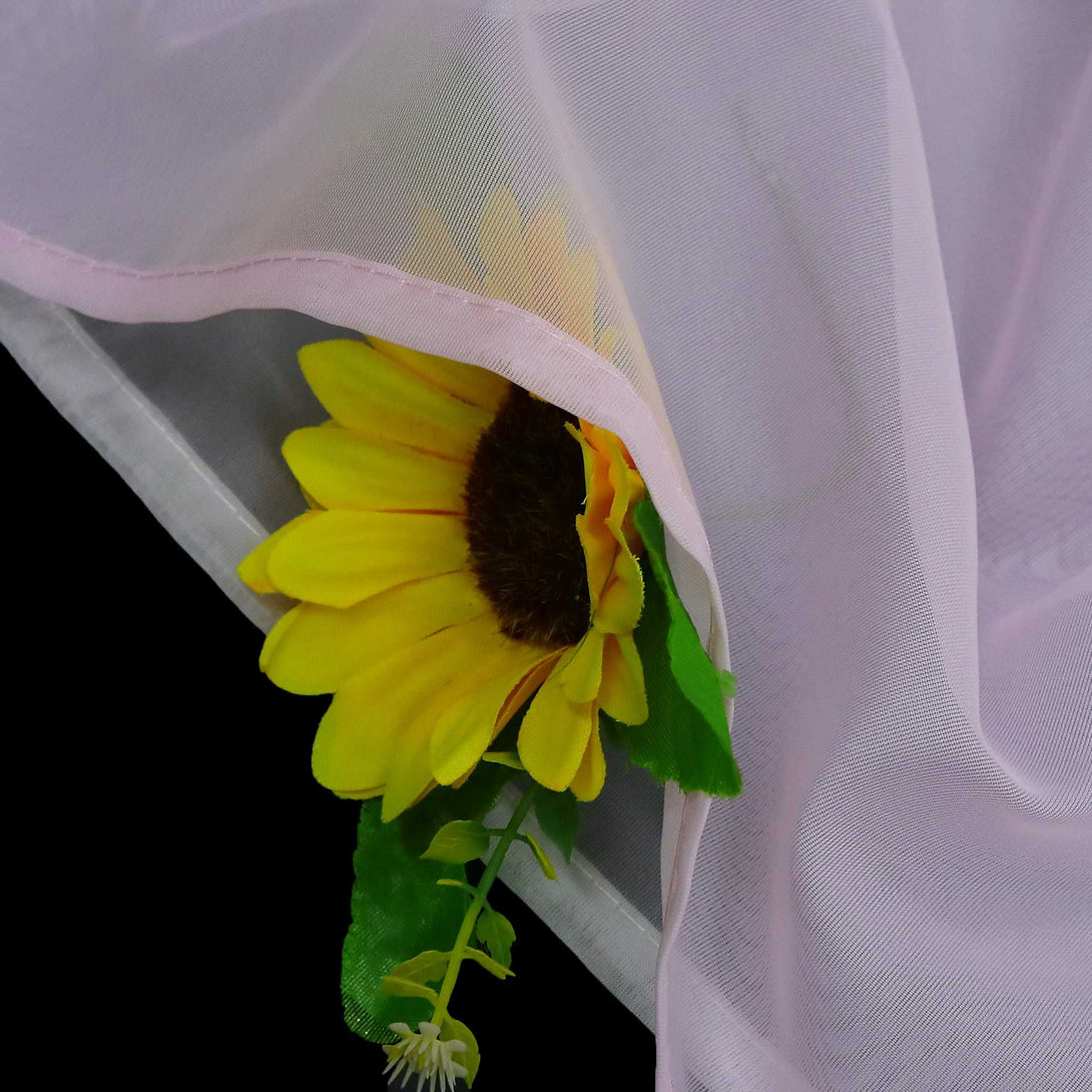 Detail des rosafarbenen Stoffs mit halbdurchsichtiger Konstruktion, darunter sind die Sonnenblumen zu sehen, die Mikro-Mesh-Konstruktion und die rosafarbene Verkleidung.
