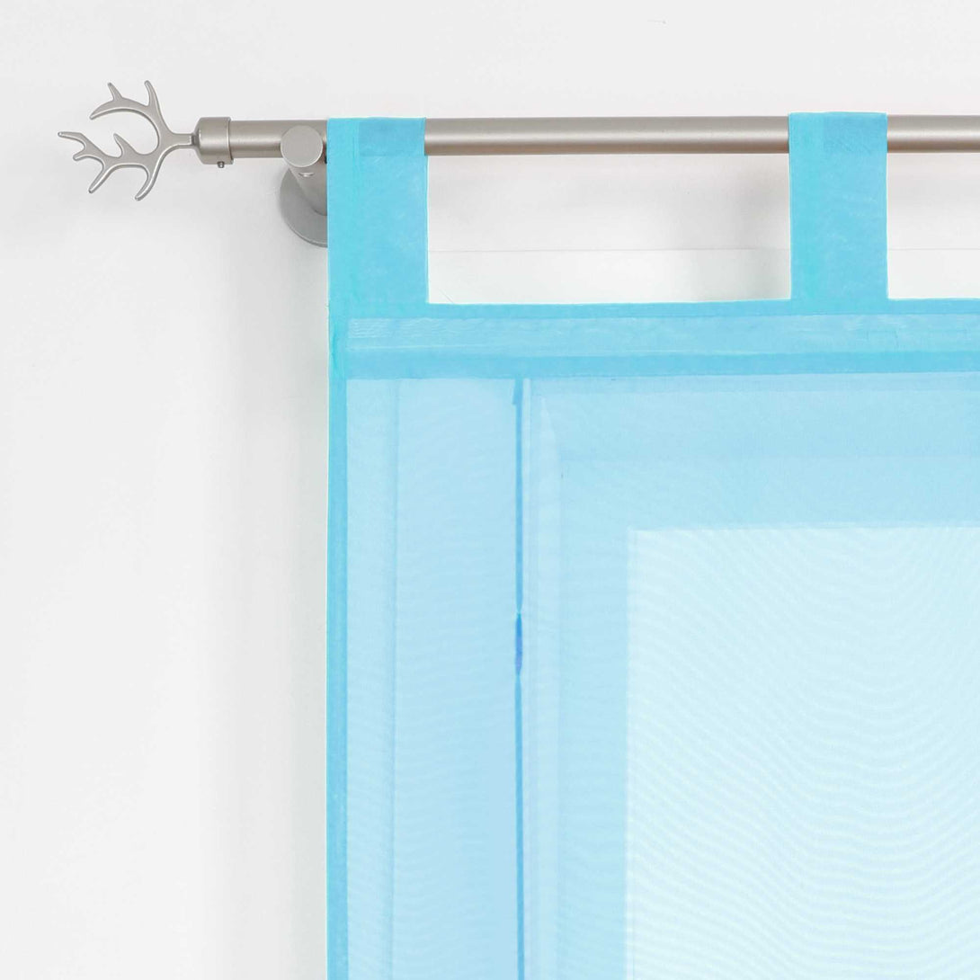 Halbtransparenter blauer Raffrollo mit praktischer Aufhängung durch Schlaufen. Die Schlaufen sorgen für einen sicheren Halt und ein schlichtes, modernes Erscheinungsbild.