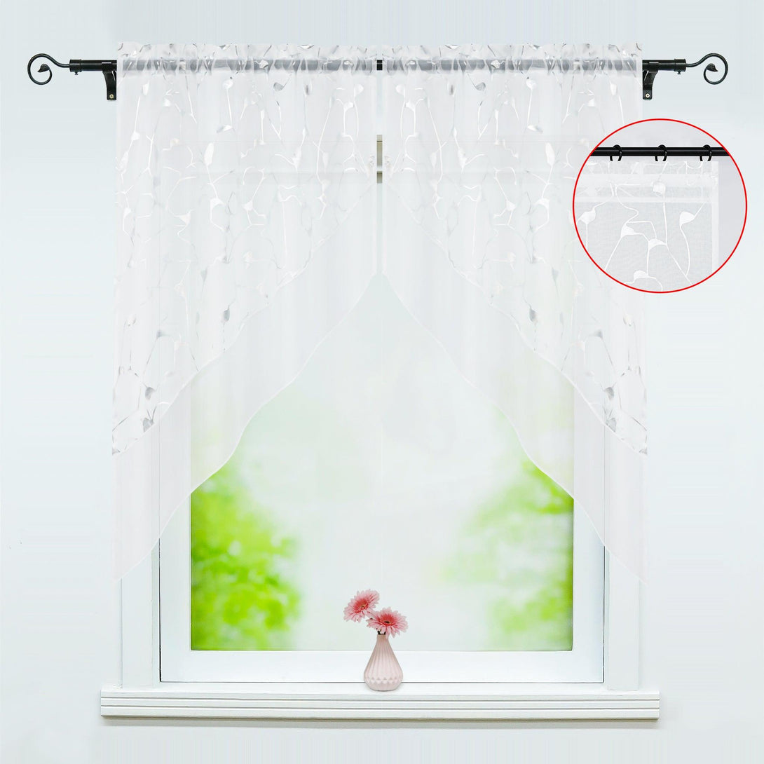 Die Hauptansicht der Double Kitchen Curtains zeigt die Vorderseite der Vorhänge. Die Vorhänge sind mit einer feinen silbernen Textur bedruckt, die beiden Teile sind abnehmbar und die Kopfleiste kann entweder gerade durch den Stoff oder mit einer runden Aufhängeschlaufe versehen werden. Die lasergeschnittenen trapezförmigen Vorhänge sind unten auf Gehrung geschnitten und hängen so, dass sie eine dreieckige Form haben.