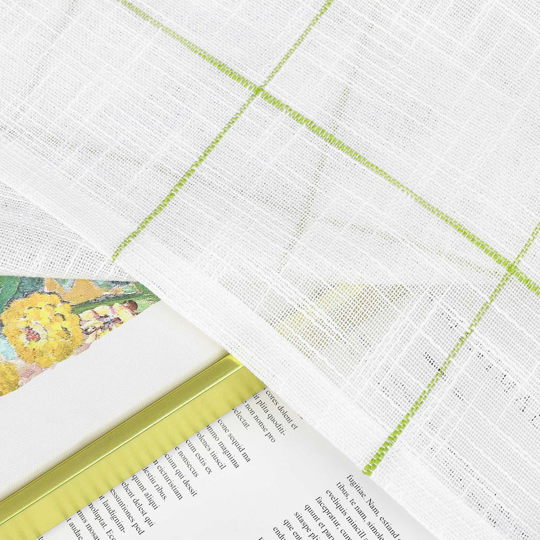 Dies ist ein Stück Stoff. Das Grundstück ist weiß, und es gibt hellgrüne Linien, die ein Gitternmuster bilden. Hinsichtlich der Textur handelt es sich um Leinen, der atmungsaktiv ist und eine unpretentiöse Textur hat. 