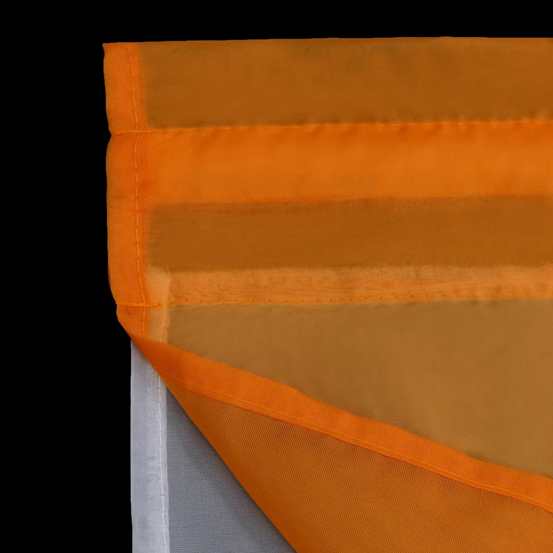 Detail der orangefarbenen Scheibengardinen, die Gardinen sind halbtransparent mit einer lichtdurchlässigen Netzstruktur, der Stoff ist dünn und hat oben und unten ein weißes Orange.