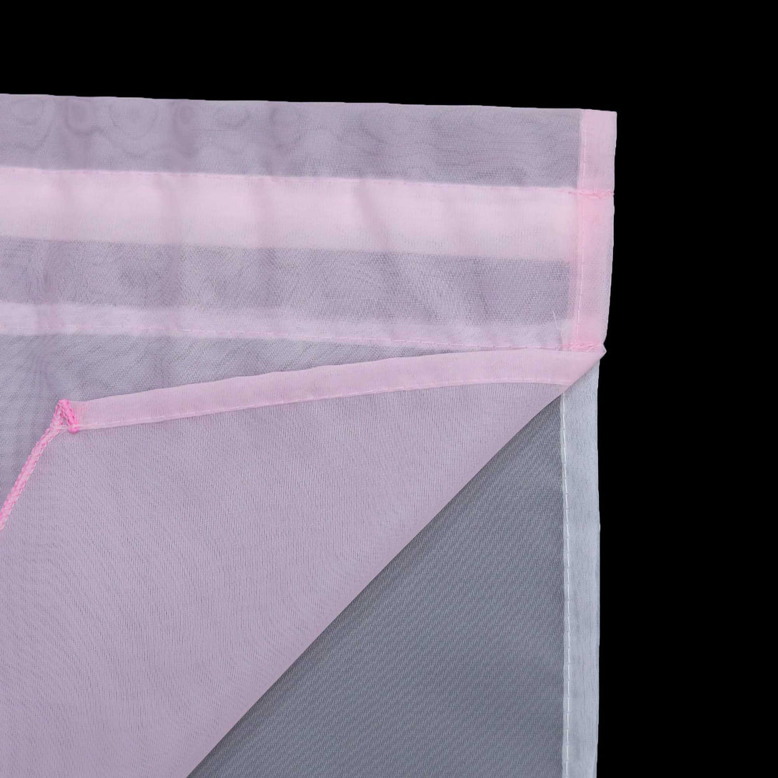 Detail eines rosafarbenen halbtransparenten Gardinenstoffs mit deutlich sichtbarem Saum und sauber gefalteten Kanten. Die feine Struktur des Stoffes lässt das Licht sanft eindringen.

