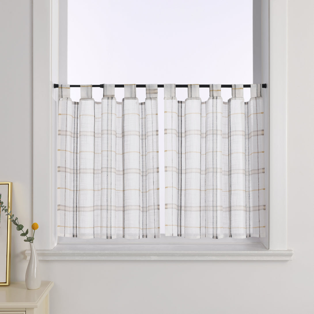 2er Set Scheibengardinen mit grauem Karomuster, ausgestattet mit praktischen Schlaufen, die elegant vor einem Fenster hängen. Die Gardinen bieten eine moderne und zugleich dezente Lösung für die Fensterdekoration.