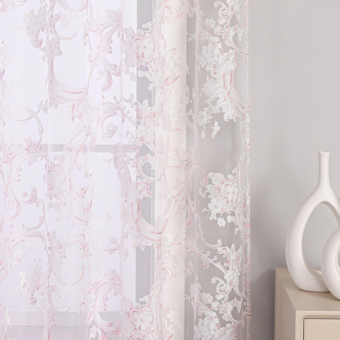 Diese Abbildung zeigt einen Teil des rosa Vorhangs, der mit einem schönen floralem Muster verziert ist. Der Vorhang ist an einem Fenster befestigt.