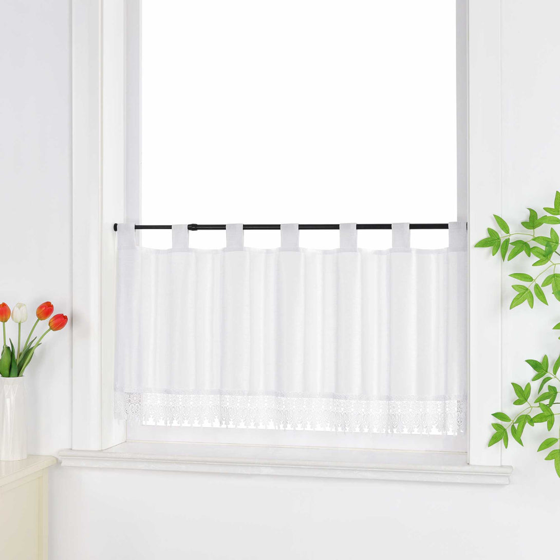 Seitlich aufgenommene Scheibengardine weiss vor dem Fenster, dekoriert mit grünen Blättern und Blüten.