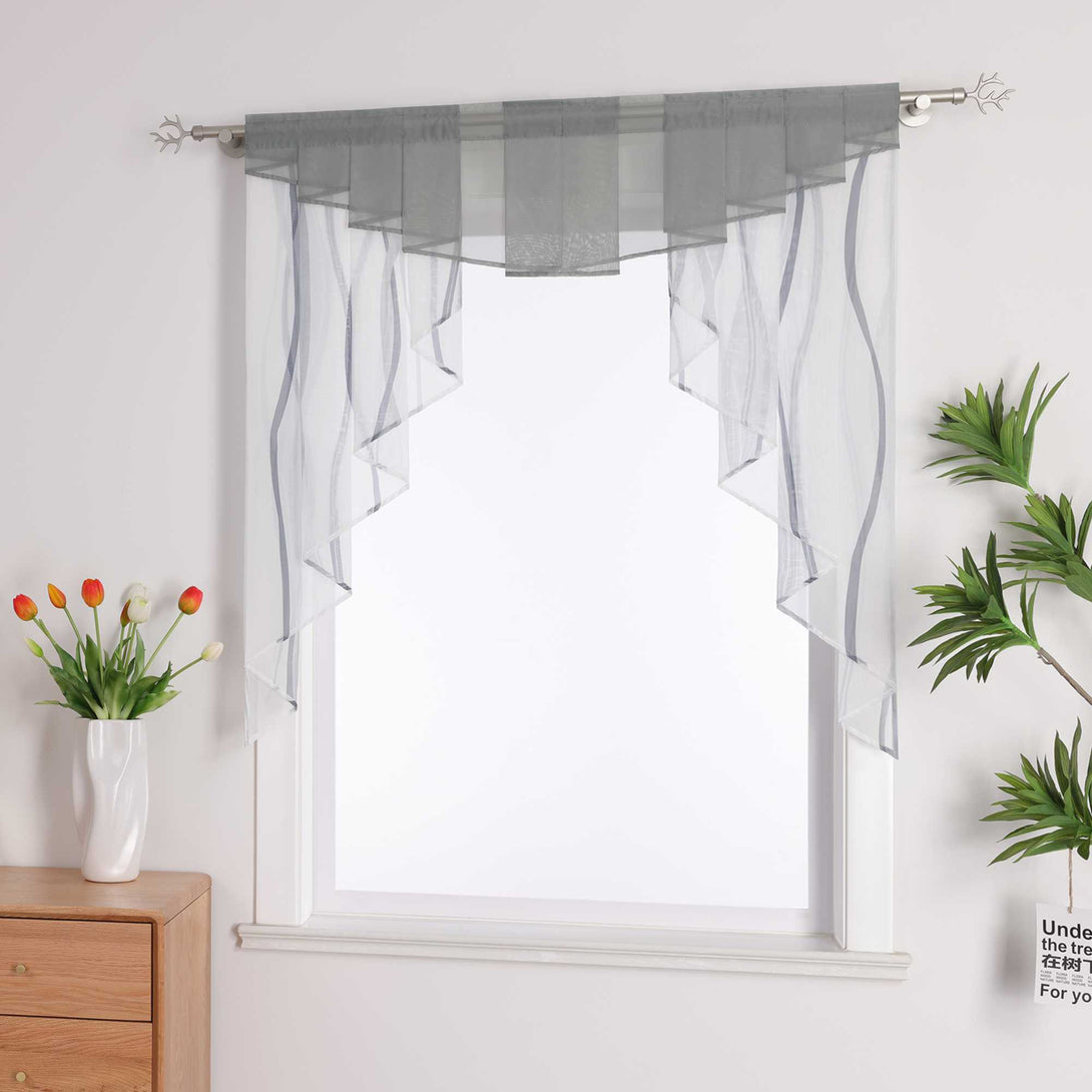 ChatGPT said:
Dieses Bild zeigt ein Fenster, an dem ein Vorhang im minimalistischen Stil hängt. Der Vorhang besteht aus einem hellgrauen, transparenten Material mit einigen Linienverzierungen, die sanfte Wellenformen erzeugen und eine leichte, elegante Atmosphäre schaffen.
Links vom Fenster befindet sich ein Holzschrank, auf dem eine weiße Vase steht, in der einige farbenfrohe Tulpen stecken.