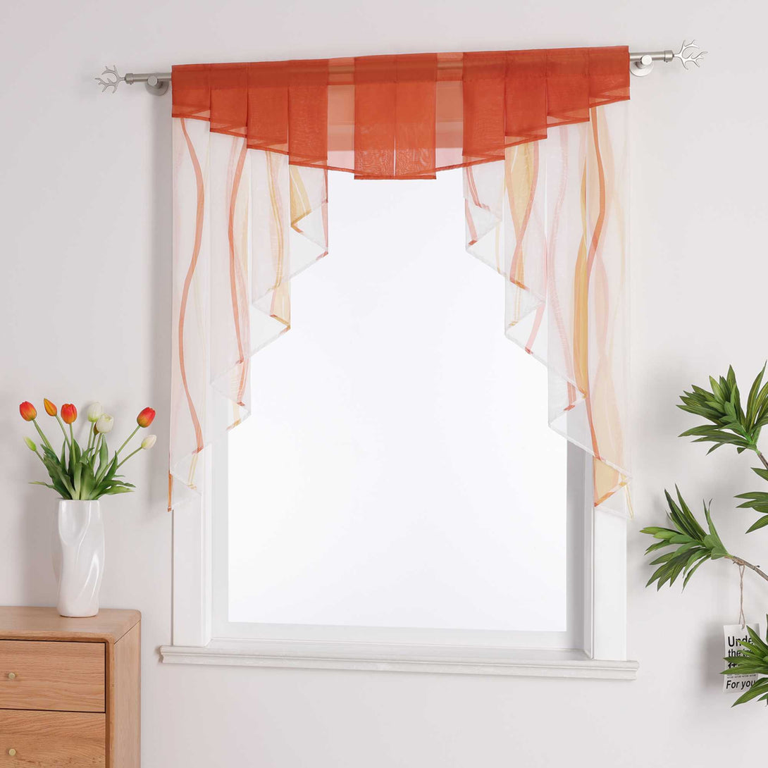 Dieser dekorative Vorhang, der am Fenster hängt, ist in Weiß gehalten und mit orangen Linien verziert. Der obere Rand ist in einem kräftigen Orange. Der Vorhang besteht aus einem leichten Material, das das Licht sanft filtert und eine warme, helle Atmosphäre im Raum schafft, während er gleichzeitig einen gewissen Schutz der Privatsphäre bietet.